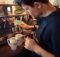 Barista working in coffee house making specialty coffee drinks